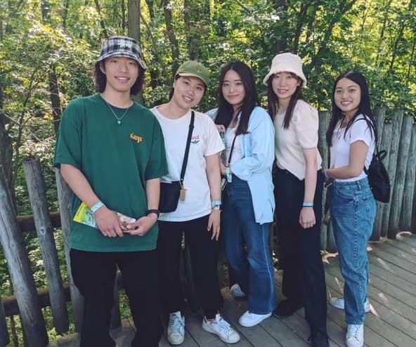 a group of people pose for a photo outside